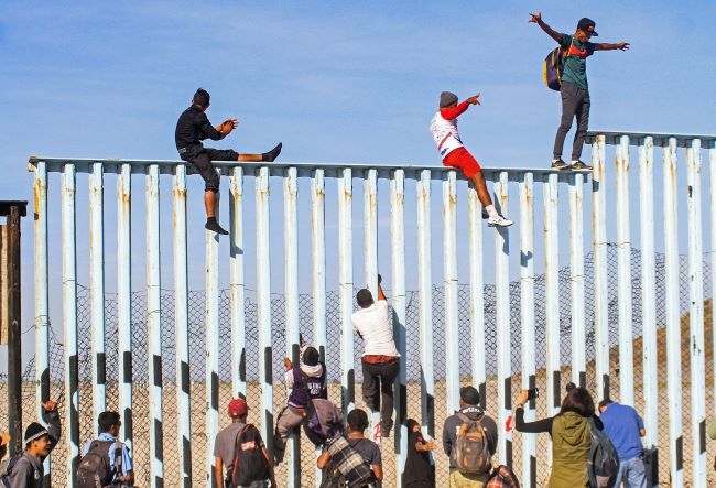 Migrantes venezolanos saltan peligrosamente muro fronterizo en Tijuana.